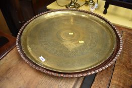 An indian style brass tray, diameter approx. 57cm and an Arts and Crafts style copper tray, having
