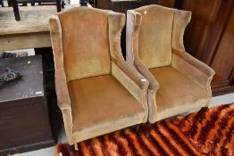 A pair of heavy framed wing back chairs, in the Queen Anne style, later ochre dralon upholstery