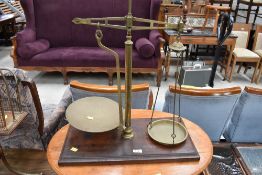A set of vintage brass balance scales, on mahogany base