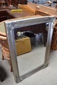 A hall way mirror having decorative silver frame