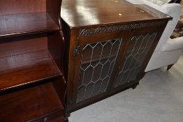 A leaded light door front oak cupboard