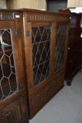 An oak display cabinet having leaded light doors and under compartment