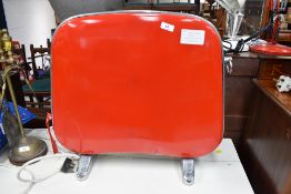 A vintage red and cream panel convector heater in the 1950s style , on chrome feet