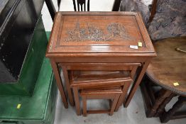 A nest of four Oriental carved tables, having glass tops