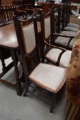 An Edwardian mahogany and inlaid salon armchair and matching chair