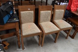 Three modern dining chairs, upholstered seats and backs