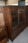 An oak display cabinet having leaded light doors and under compartment