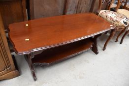 A modern coffee table in a red stained wood