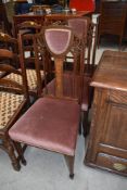 A pair of Edwardian mahogany and inlaid salon chairs having dralon seat and shoulder pad, on