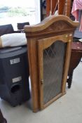 A modern oak corner cupboard with leaded effect glass