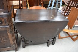A traditional dark oak gateleg table, width approx. 90cm