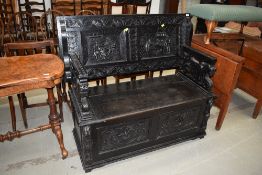 A 19th Century dark stained monks bench, having illustrative tavern panel decoration and dog of fo