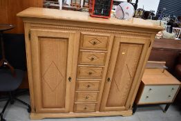 A modern golden oak effect cupboard having central drawer section, dimensions approx. W145 D52