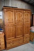 A modern pine triple wardrobe, Kenilworth farmhouse design, having drawer base, width approx. 140cm