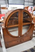 An Art Deco oak display cabinet having circular display section, with glazed upper and frosted lower