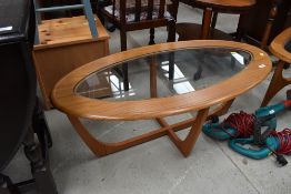 A vintage teak EFFECT laminate and glass oval top coffee table