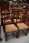A set of four traditional oak ladder back dining chairs
