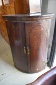 An antique corner cupboard possibly mid 18th century having decorated band frontage