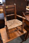A period oak childs rocking chair having sea grass seat, signs of past worm but not active