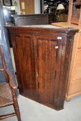 A Georgian oak corner cupboard having interesting shelved interior, width approx. 85cm