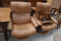 Two tan leather stressless armchairs and a footstool