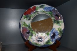 A Highland stoneware mirror having decorative abstract Anemone pattern to frame.