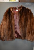 A short vintage fur jacket having leather inserts to back of arms, fully lined and in soft and