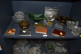 An assortment of vintage glass ash trays and cigarette cases.