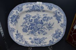 A large antique blue and white platter having transfer pattern of floral scene and birds.