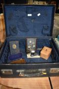 A selection of curios and collectables in suitcase including bakelite frame Post office savings bank