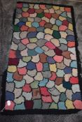 A vintage peg rug having colourful shell shaped sections, some wear to the edges in places..