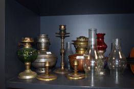 A collection of Vintage and antique oil lamps, chimneys, and candlestick holders some having arts