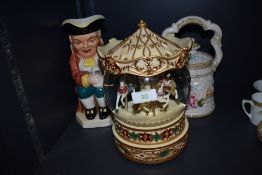 A large musical snow/glitter dome having carousel scene, a floral tea pot and a Burlington ware