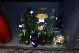 A collection of glass medical bottles, eye baths, codd bottles and more.