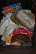 A box full of vintage and modern table linen, mats and similar.