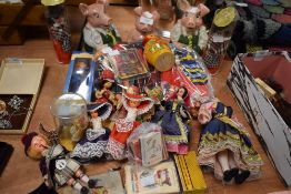 A collection of souvenir dolls, vintage card games, a Noddy book and three wade Natwest pigs.