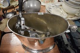 A large ice bucket having decorative handles and a vintage bar mounted cork screw with wooden