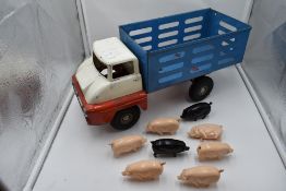 A Triang tin plate Farm Lorry with 6 pink and two black plastic pigs,having blue body, white cab and