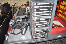 A Sony Playstation with two controllers and various games including Colin Mcrae Rally 2.0, Premier
