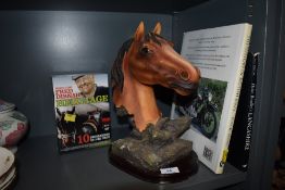 A mixed collection of items including a horse head figurine, a book on British bikes and one on