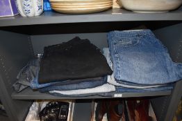 Thirteen pairs of jeans mainly Levi, and a Wrangler denim gillet with tags attached.
