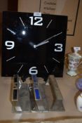 A black glass clock and three grab handles or similar.