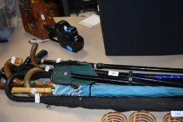 A selection of walking sticks canes and umbrellas