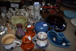 An assortment of studio pottery pieces among which are vases, candle sticks and bowls, a mix of