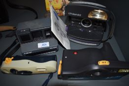 Four Polaroid cameras including Polaroid Cool Cam, Polaroid Impulse, Polaroid Joy Cam and Polaroid I