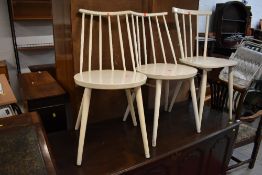 A set of three vintage painted kitchen chairs having rail and stick backs, in the Ercol style