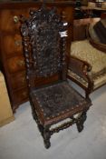 A Jacobean style oak hall chair having detailed dragon and angel leather work to seat and foliate