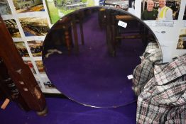 A circular hall way mirror with bevel edged glass