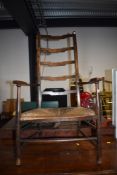 A traditional stained frame rush seated ladder back carver chair
