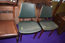 A pair of teak Danish style office chairs with green vinyl upholstery